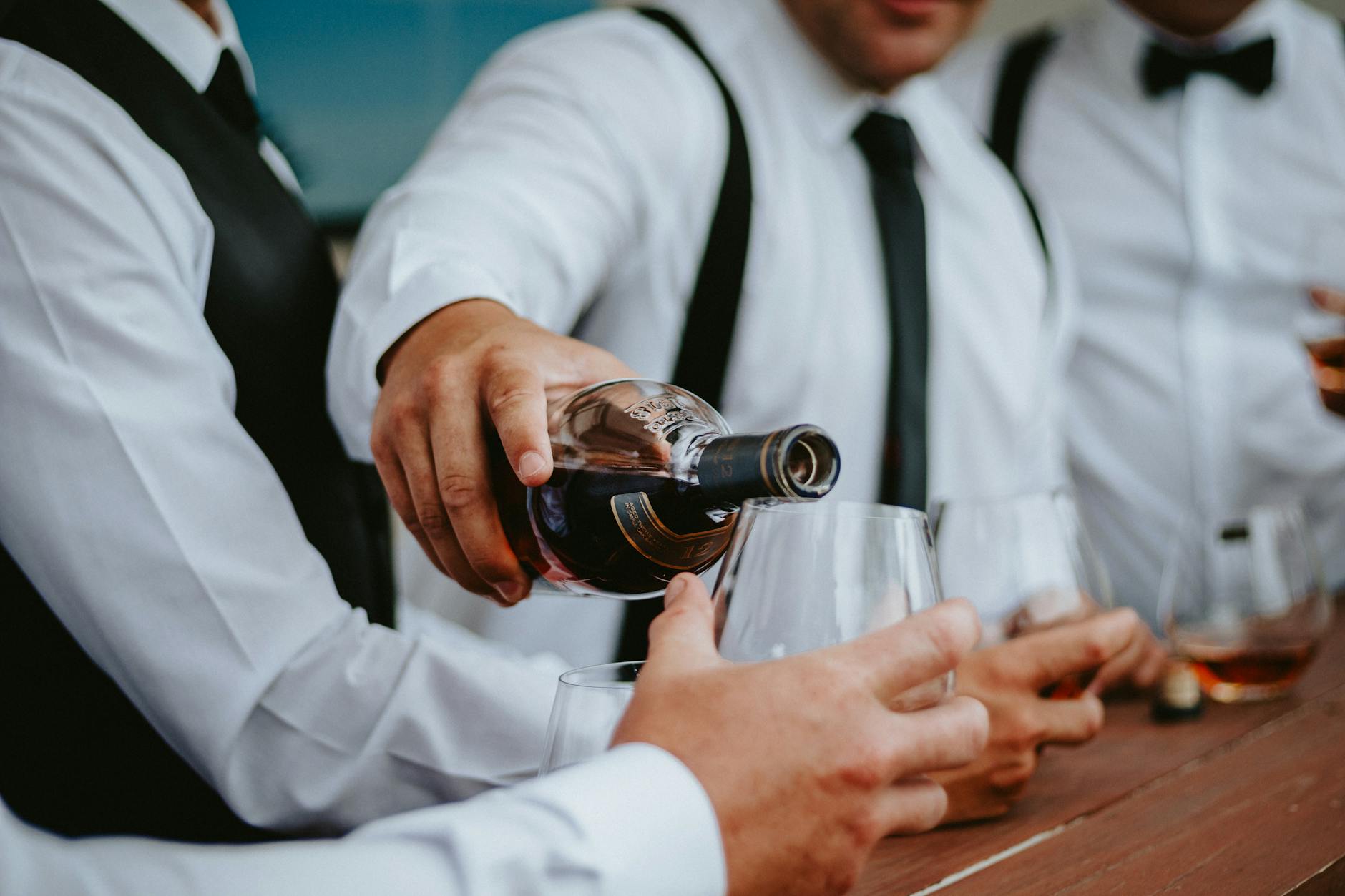 man pouring wine into glass